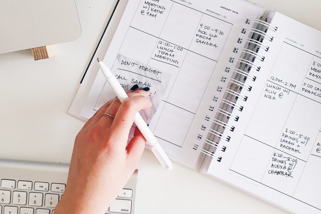 Hand holding a pen touching a paper agenda